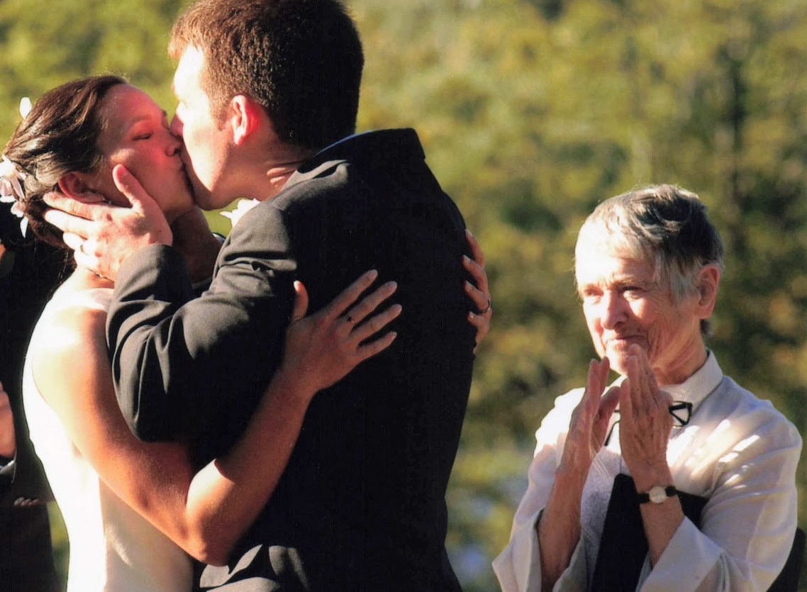 Sister of Charity Marie de Paul Combo watches Thomas C. Fox's daughter, Christine, and new husband, Chris kiss during their wedding in a New Hampshire park.